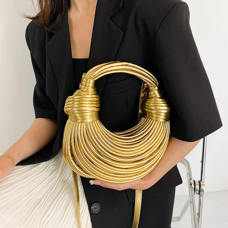Make a statement with this gold luxury designer brand handwoven noodle bag. With a rope-knotted hobo design and a chic silver evening clutch, this bag is the epitome of high fashion and sophistication. -