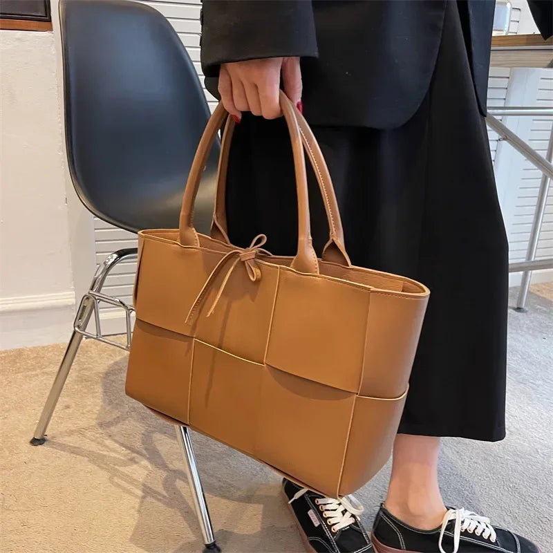 Make a fashion statement with this large capacity handbag. Crafted with stylish woven leather, this tote bag is perfect for adding a touch of elegance to your everyday outfit. -