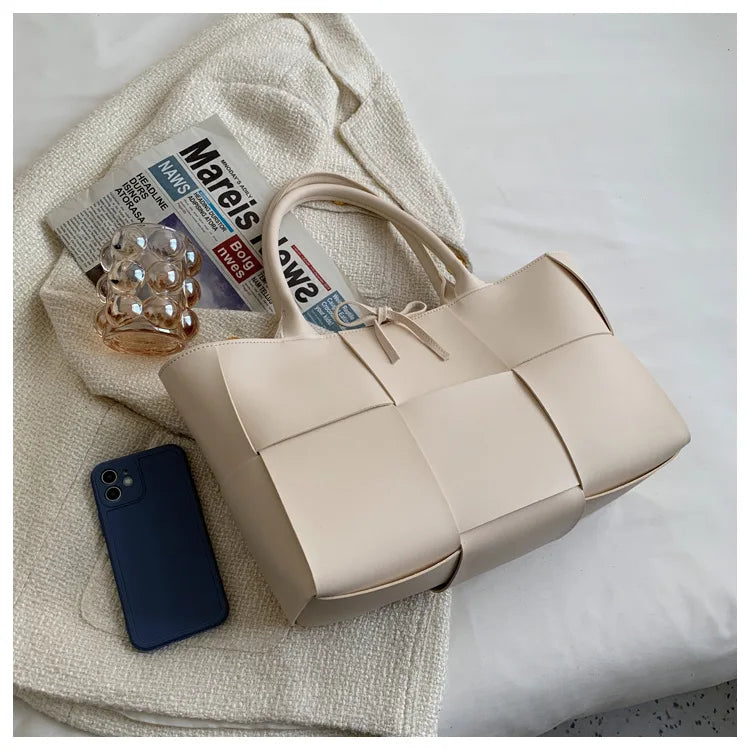 Make a fashion statement with this large capacity handbag. Crafted with stylish woven leather, this tote bag is perfect for adding a touch of elegance to your everyday outfit. -