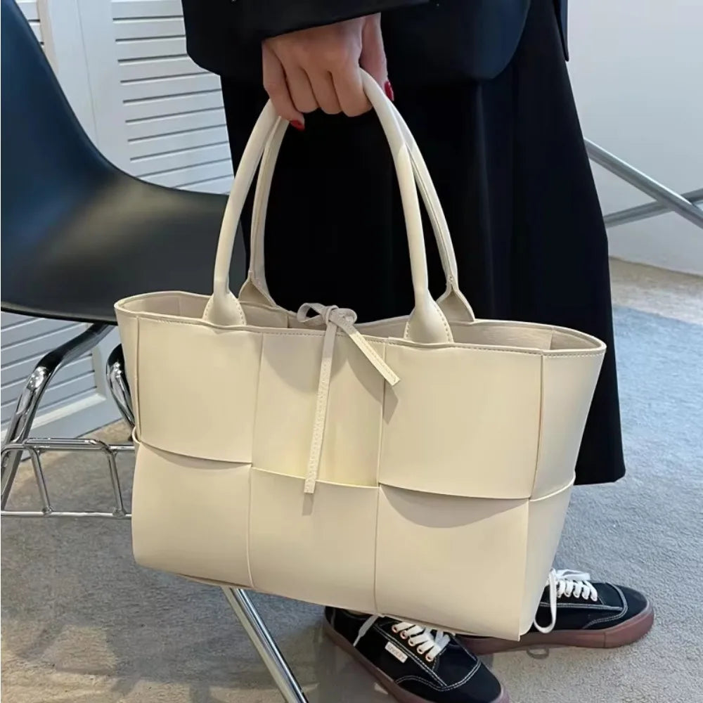 Make a fashion statement with this large capacity handbag. Crafted with stylish woven leather, this tote bag is perfect for adding a touch of elegance to your everyday outfit. -