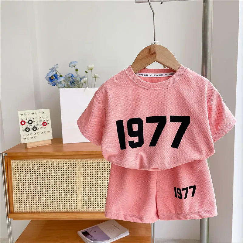 Dress your little athletes in style with this trendy two-piece set—featuring printed short-sleeve tops and shorts for both boys and girls! -