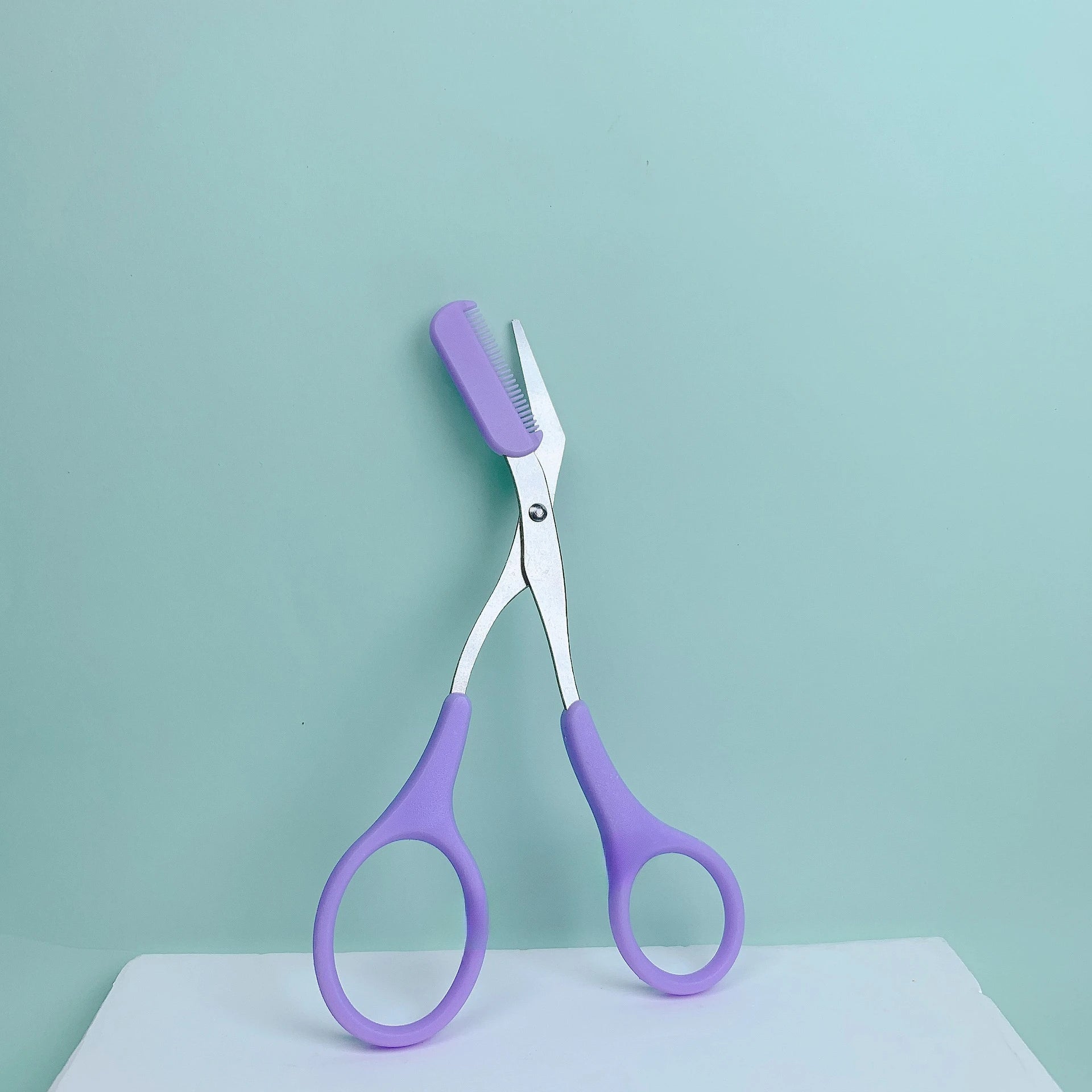 Eyebrow trimming scissors with built-in comb -