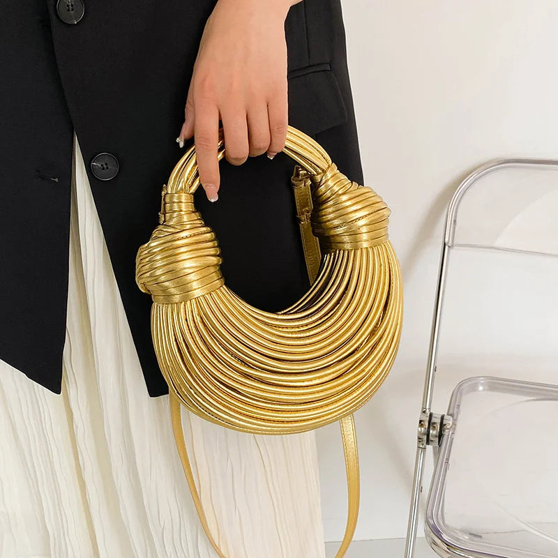 Make a statement with this gold luxury designer brand handwoven noodle bag. With a rope-knotted hobo design and a chic silver evening clutch, this bag is the epitome of high fashion and sophistication. -
