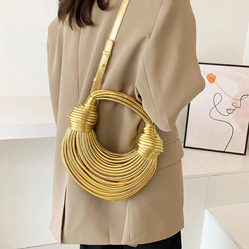 Make a statement with this gold luxury designer brand handwoven noodle bag. With a rope-knotted hobo design and a chic silver evening clutch, this bag is the epitome of high fashion and sophistication. -