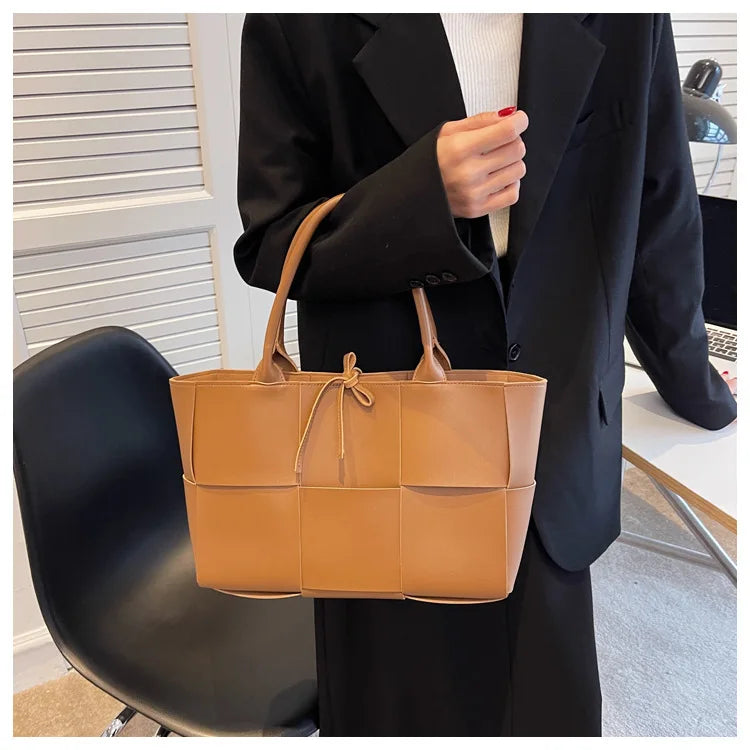 Make a fashion statement with this large capacity handbag. Crafted with stylish woven leather, this tote bag is perfect for adding a touch of elegance to your everyday outfit. -