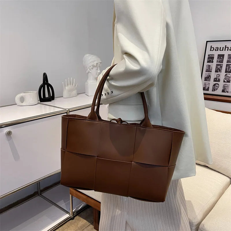 Make a fashion statement with this large capacity handbag. Crafted with stylish woven leather, this tote bag is perfect for adding a touch of elegance to your everyday outfit. -