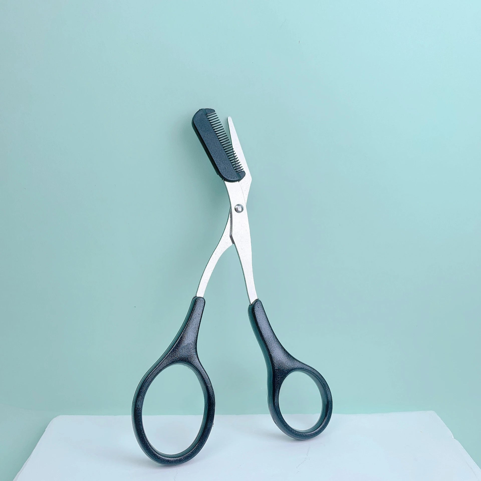 Eyebrow trimming scissors with built-in comb -