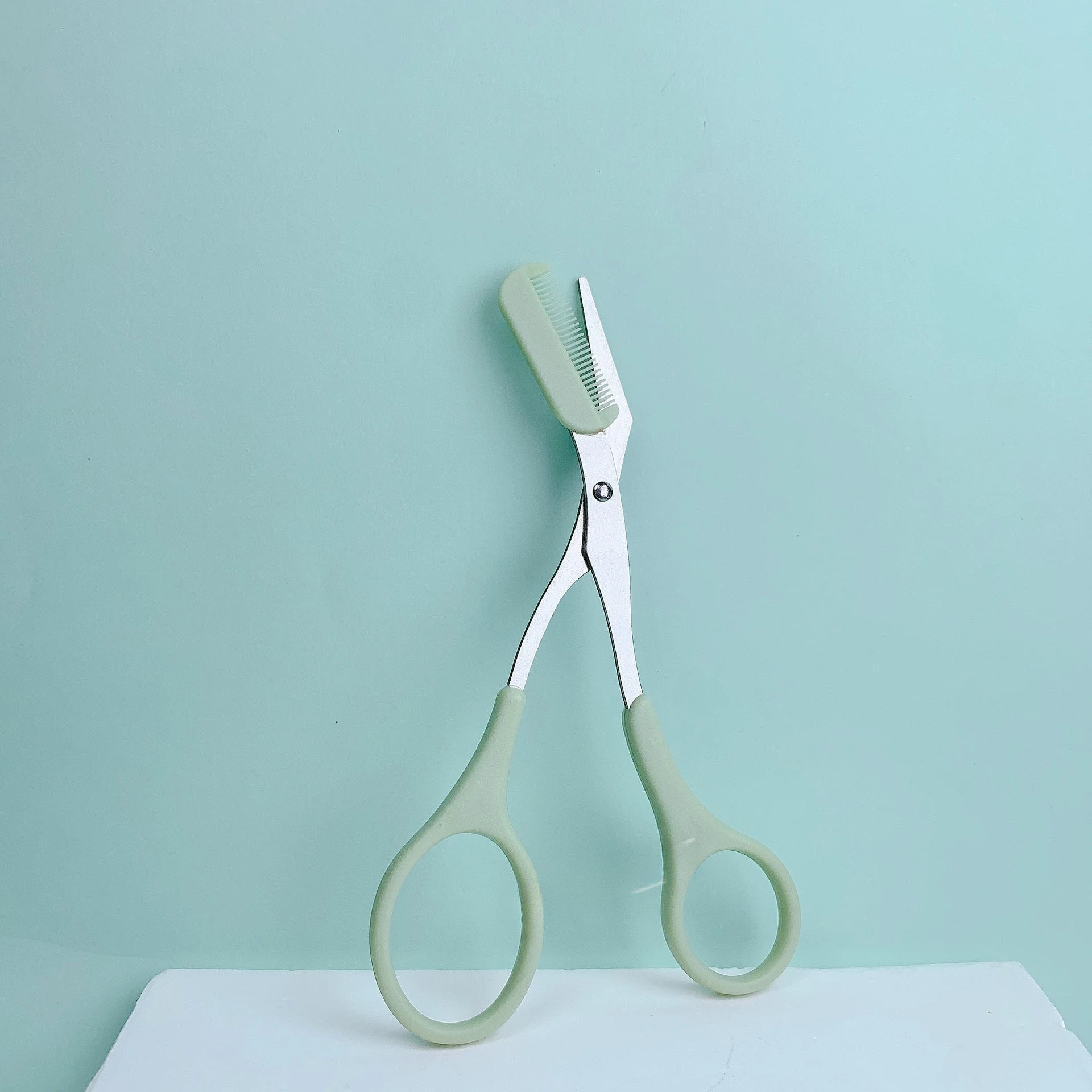 Eyebrow trimming scissors with built-in comb -