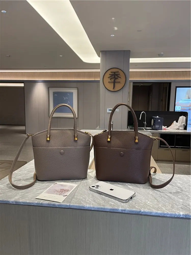 Elevate your style with this elegant tote bag. Crafted from genuine leather, this bag exudes sophistication and is the perfect accessory for a chic and classy look. -