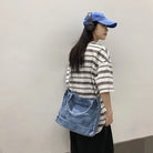 Elevate your casual look with this denim shoulder bag for women. Featuring a large design and zipper closure, this bag is perfect for shopping and everyday use, adding a touch of style to your outfit. -