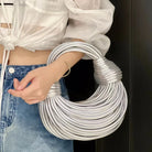 Make a statement with this gold luxury designer brand handwoven noodle bag. With a rope-knotted hobo design and a chic silver evening clutch, this bag is the epitome of high fashion and sophistication. -