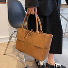 Make a fashion statement with this large capacity handbag. Crafted with stylish woven leather, this tote bag is perfect for adding a touch of elegance to your everyday outfit. -