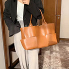 Make a fashion statement with this large capacity handbag. Crafted with stylish woven leather, this tote bag is perfect for adding a touch of elegance to your everyday outfit. -
