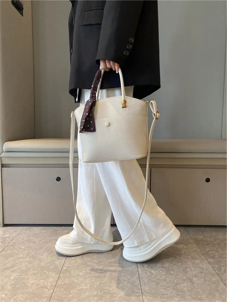 Elevate your style with this elegant tote bag. Crafted from genuine leather, this bag exudes sophistication and is the perfect accessory for a chic and classy look. -