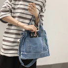 Elevate your casual look with this denim shoulder bag for women. Featuring a large design and zipper closure, this bag is perfect for shopping and everyday use, adding a touch of style to your outfit. -