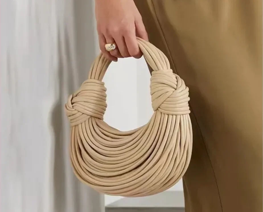 Make a statement with this gold luxury designer brand handwoven noodle bag. With a rope-knotted hobo design and a chic silver evening clutch, this bag is the epitome of high fashion and sophistication. -
