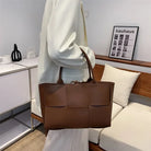 Make a fashion statement with this large capacity handbag. Crafted with stylish woven leather, this tote bag is perfect for adding a touch of elegance to your everyday outfit. -