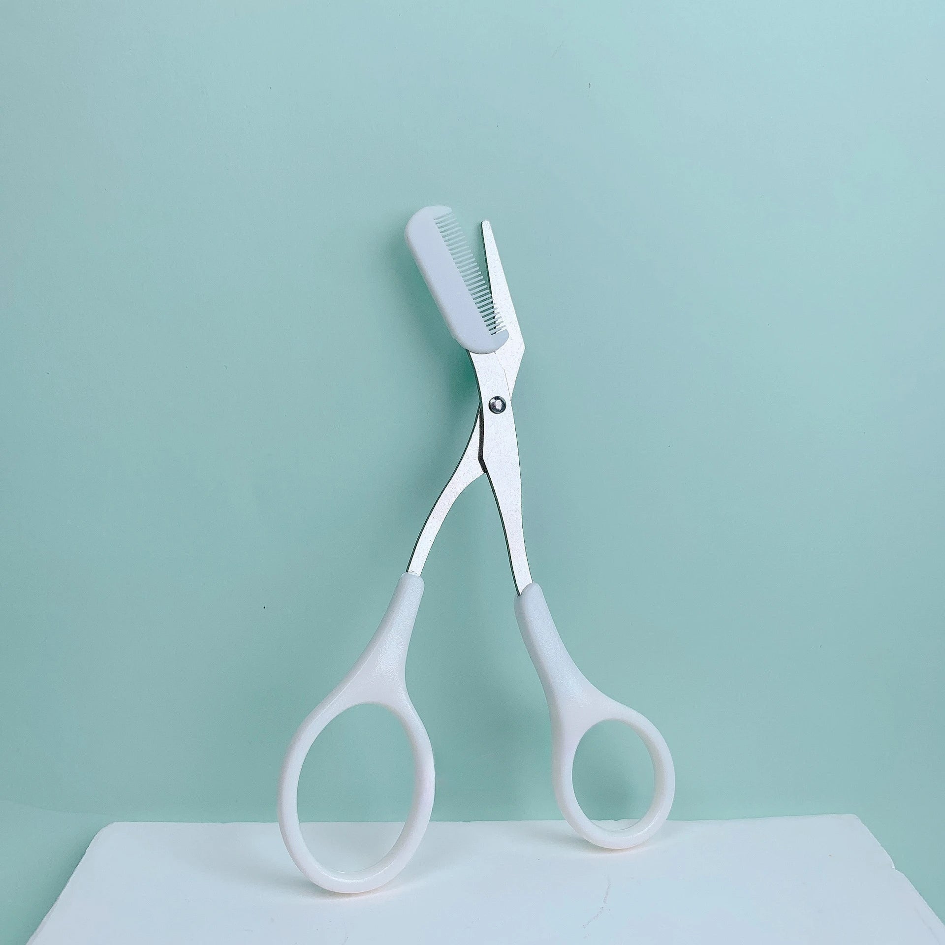 Eyebrow trimming scissors with built-in comb -