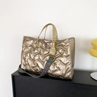 Stay on-trend with this fashion-forward large tote padded handbag featuring a designer quilted design. This stylish accessory is perfect for adding a touch of sophistication and elegance to your ensemble. -
