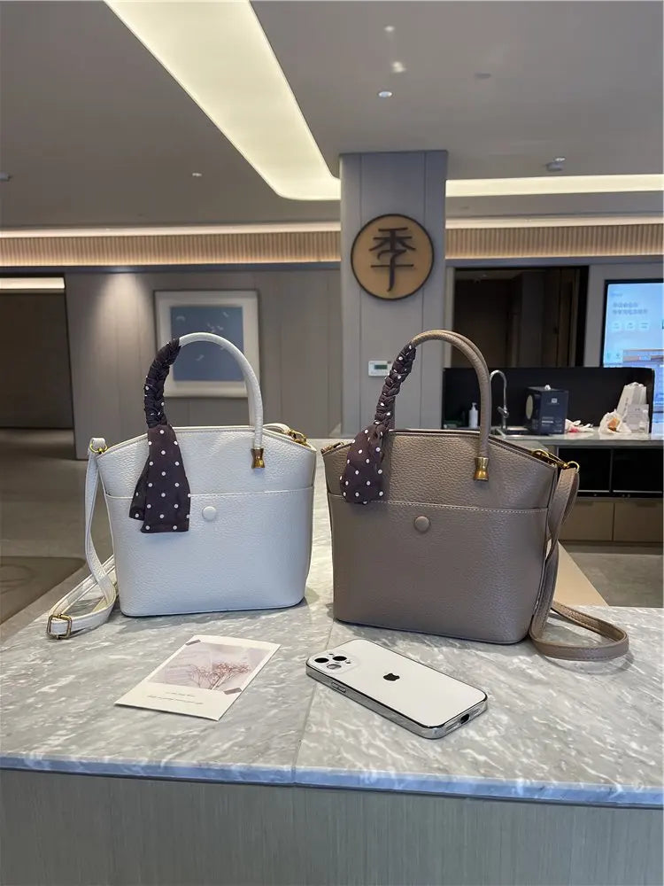 Elevate your style with this elegant tote bag. Crafted from genuine leather, this bag exudes sophistication and is the perfect accessory for a chic and classy look. -