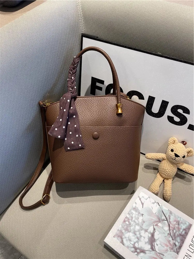 Elevate your style with this elegant tote bag. Crafted from genuine leather, this bag exudes sophistication and is the perfect accessory for a chic and classy look. -