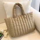 Carry your essentials in style with this large capacity and cotton-padded tote bag designed for ladies. Featuring a solid color and casual fashion, this bag is both practical and fashionable for everyday use. -