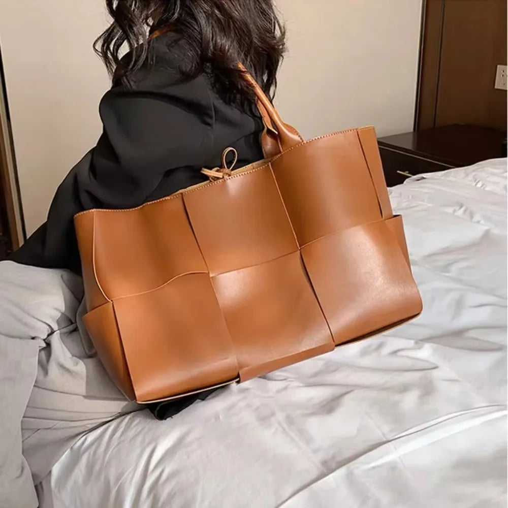 Make a fashion statement with this large capacity handbag. Crafted with stylish woven leather, this tote bag is perfect for adding a touch of elegance to your everyday outfit. -