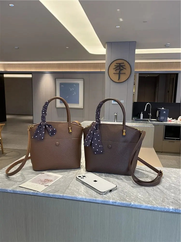 Elevate your style with this elegant tote bag. Crafted from genuine leather, this bag exudes sophistication and is the perfect accessory for a chic and classy look. -