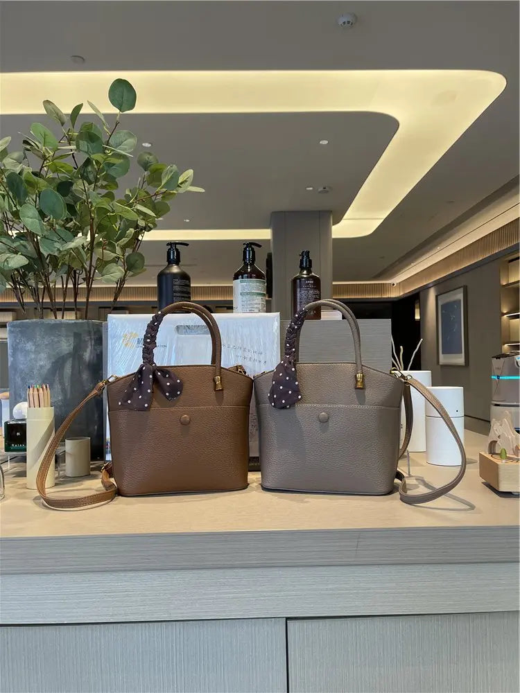 Elevate your style with this elegant tote bag. Crafted from genuine leather, this bag exudes sophistication and is the perfect accessory for a chic and classy look. -