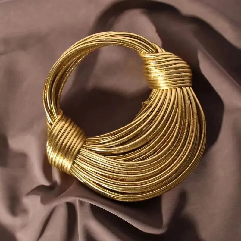 Make a statement with this gold luxury designer brand handwoven noodle bag. With a rope-knotted hobo design and a chic silver evening clutch, this bag is the epitome of high fashion and sophistication. -