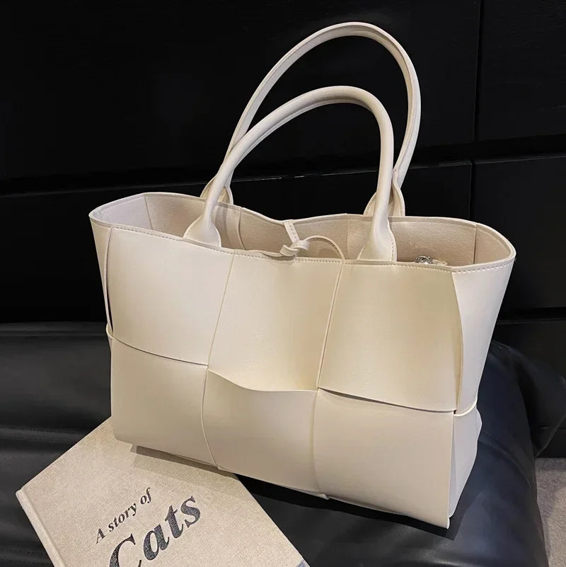 Make a fashion statement with this large capacity handbag. Crafted with stylish woven leather, this tote bag is perfect for adding a touch of elegance to your everyday outfit. -