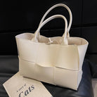 Make a fashion statement with this large capacity handbag. Crafted with stylish woven leather, this tote bag is perfect for adding a touch of elegance to your everyday outfit. -