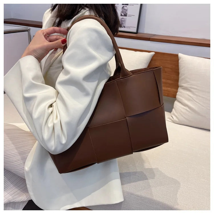 Make a fashion statement with this large capacity handbag. Crafted with stylish woven leather, this tote bag is perfect for adding a touch of elegance to your everyday outfit. -