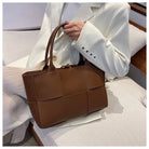 Make a fashion statement with this large capacity handbag. Crafted with stylish woven leather, this tote bag is perfect for adding a touch of elegance to your everyday outfit. -