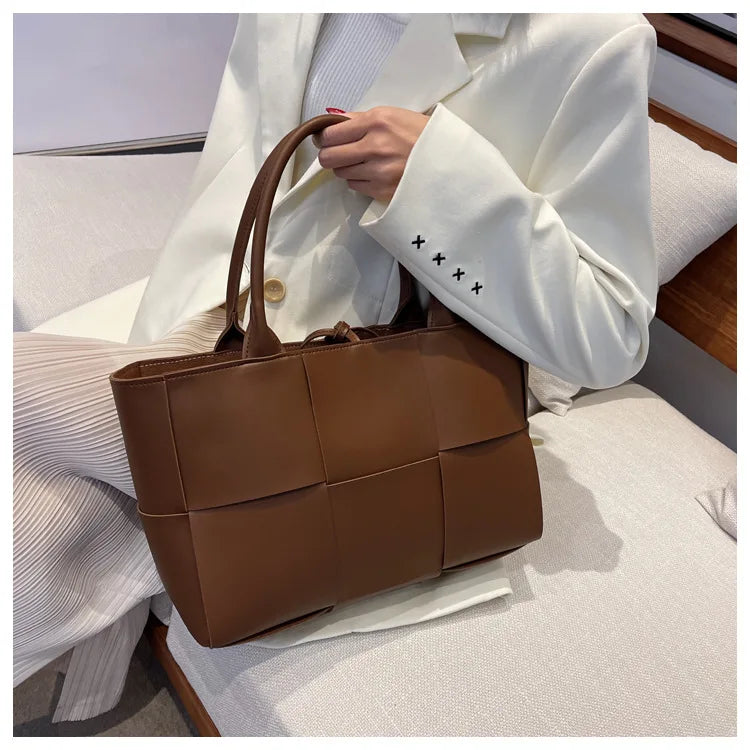 Make a fashion statement with this large capacity handbag. Crafted with stylish woven leather, this tote bag is perfect for adding a touch of elegance to your everyday outfit. -