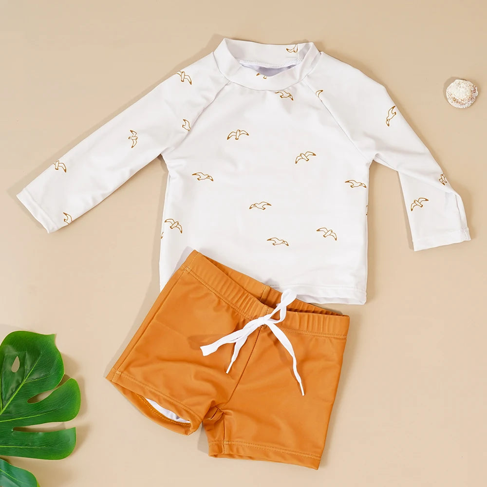 Make a splash in style with this fashionable and cute long-sleeve swimsuit for baby boys and girls—perfect for pool days and swim fun! -