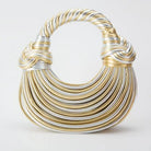 Make a statement with this gold luxury designer brand handwoven noodle bag. With a rope-knotted hobo design and a chic silver evening clutch, this bag is the epitome of high fashion and sophistication. -